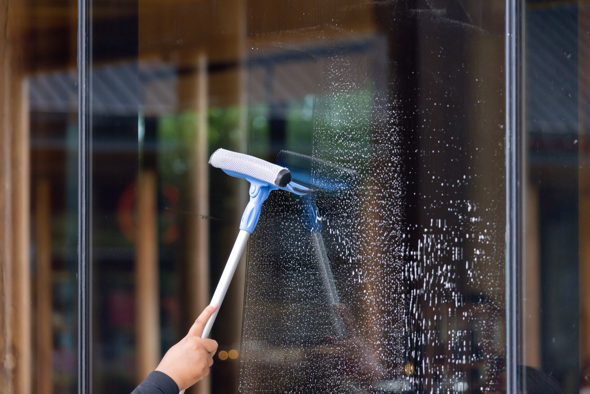 A person is cleaning a window with a squeegee